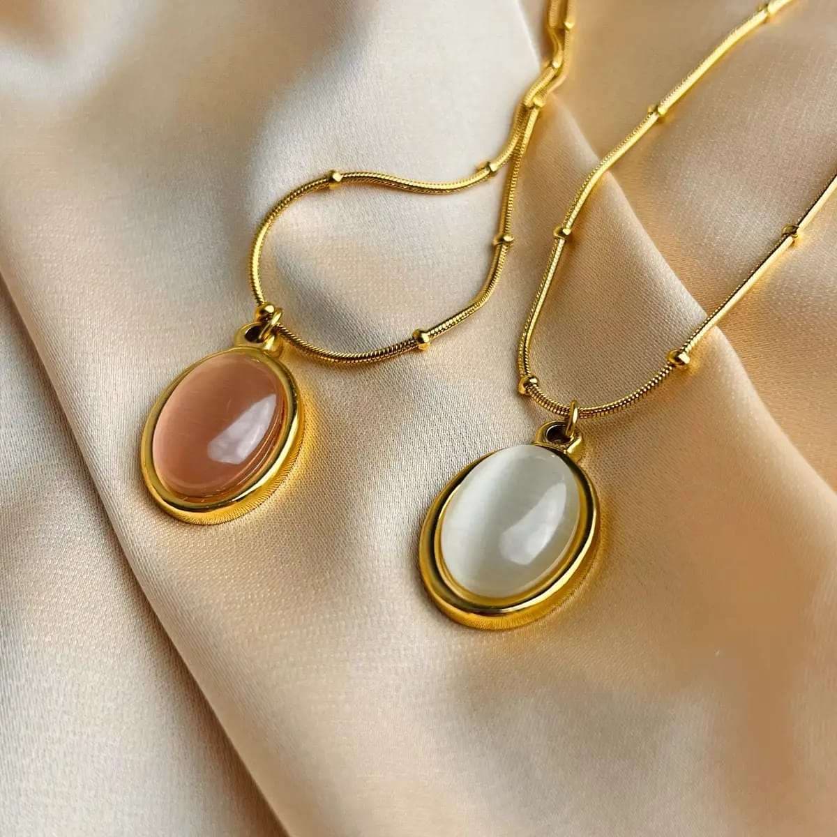 Gold-toned pendant necklaces featuring bezel-set oval cat's eye stones on delicate beaded chains